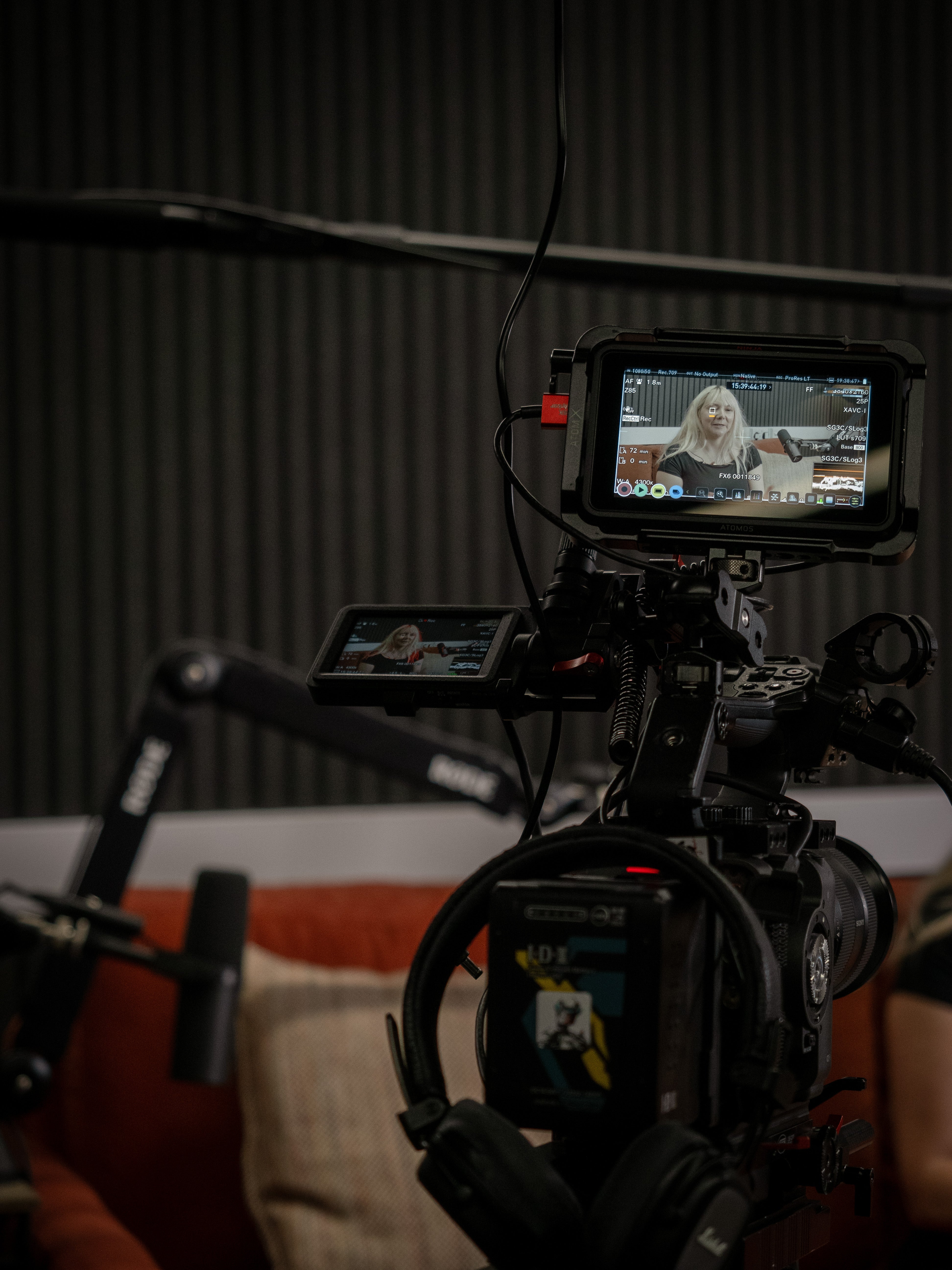 Video camera with a monitor displaying a person in a room with a neutral background