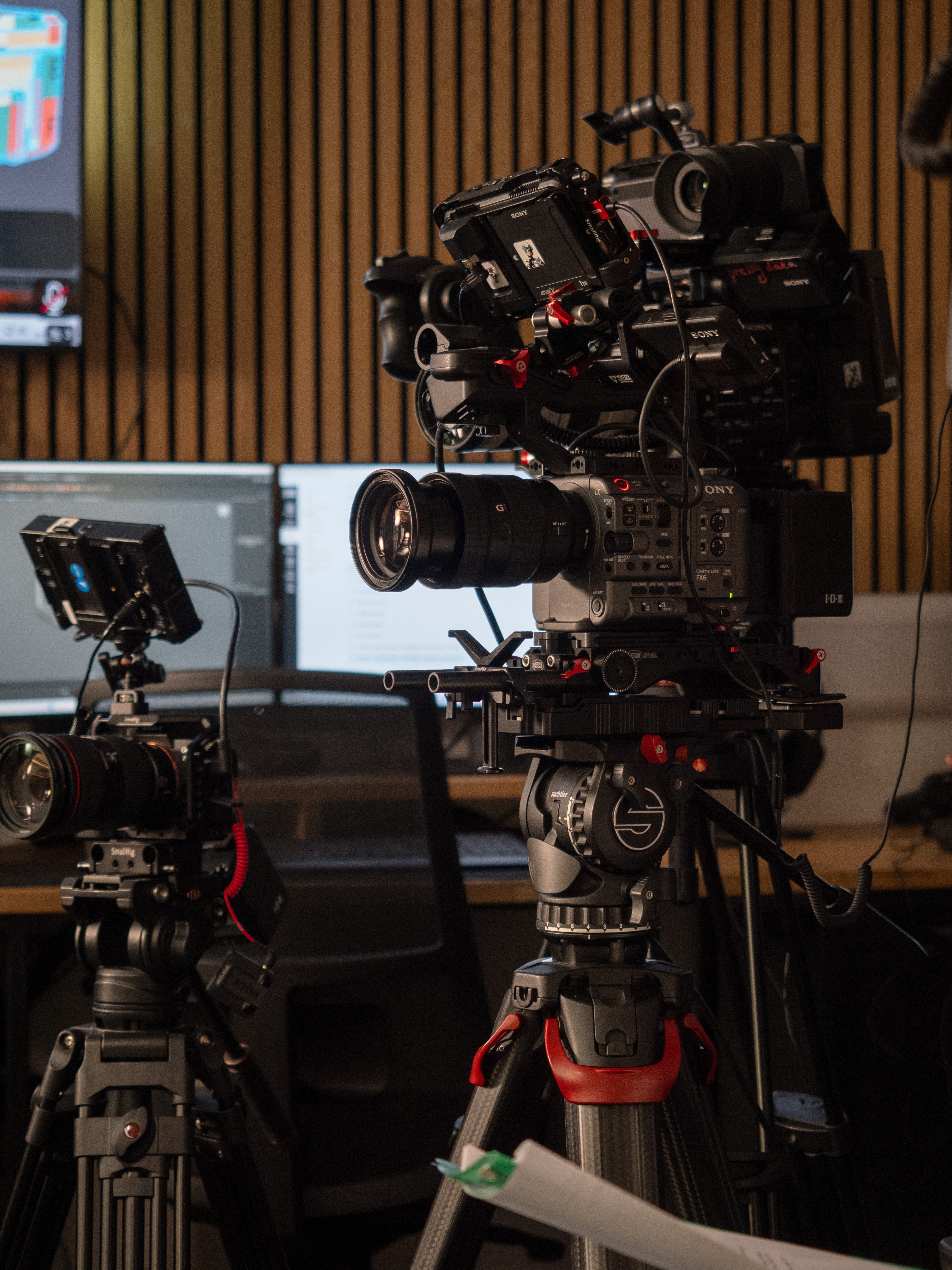 Professional video camera setup with multiple cameras and monitors in a studio.